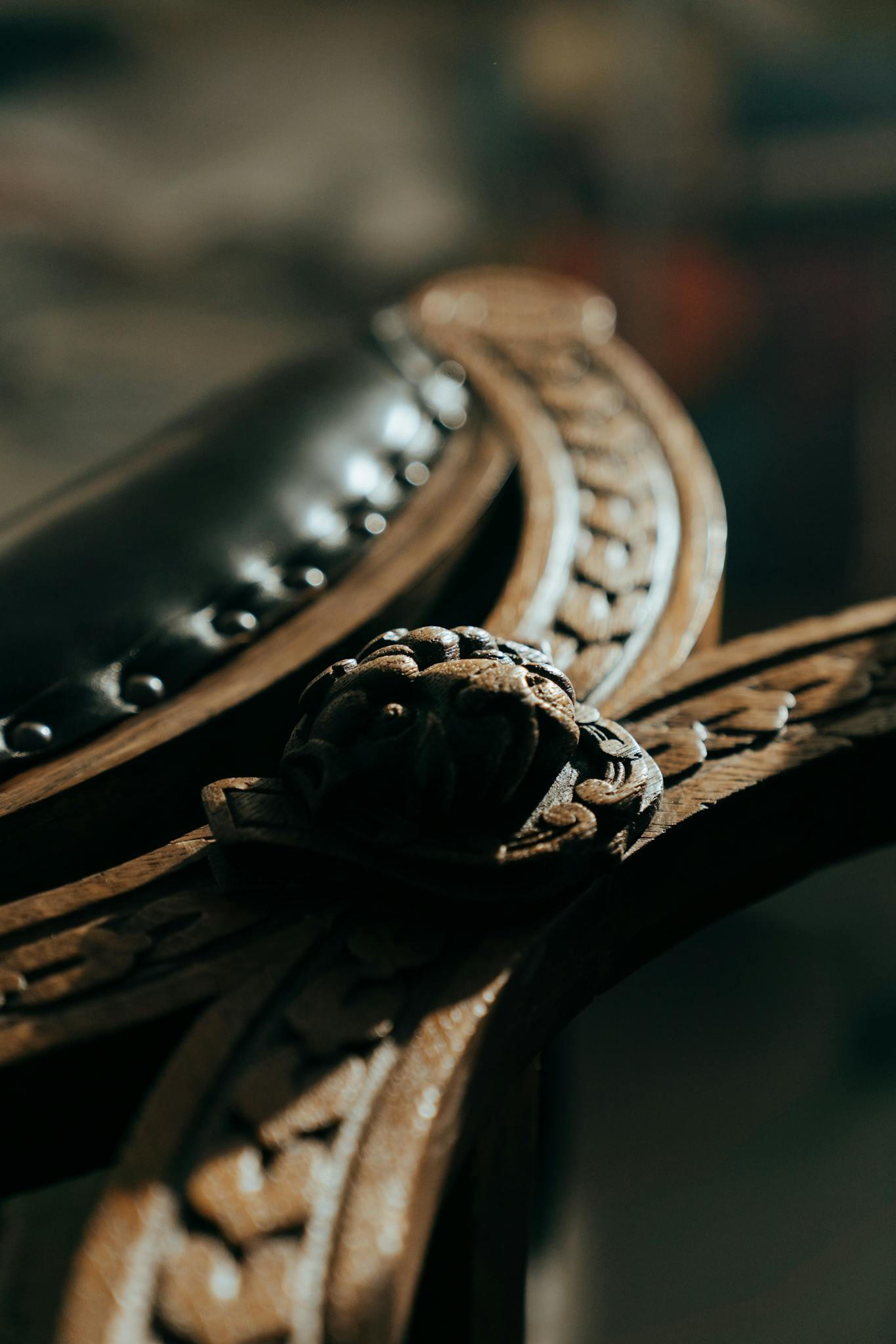 Detailed view of carved wood and leather from vintage furniture in a workshop setting.